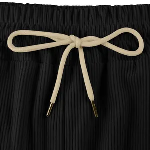 Détail d'un short cargo en velours côtelé avec taille élastique et cordon de serrage beige.