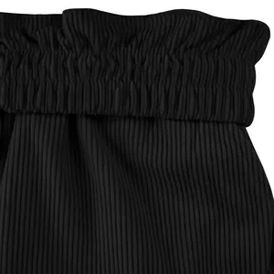 Gros plan détaillé de la taille élastique à volants sur un short cargo en velours noir pour homme