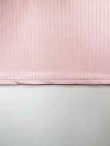 Détail en gros plan du tissu en maille côtelée rose et des coutures de l'ourlet du débardeur