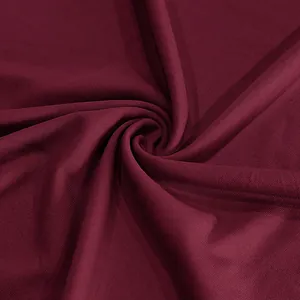 Gros plan macro montrant la texture respirante du tissu de sport bordeaux à séchage