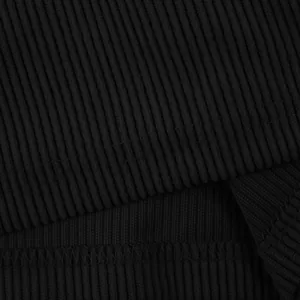 Gros plan sur la texture du velours côtelé noir et les détails de couture du short cargo.