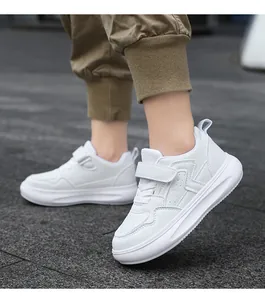Gros plan de baskets blanches pour enfants à semelles épaisses portées avec un jogging