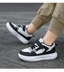 Gros plan sur les baskets pour garçons à semelles épaisses noires et blanches.