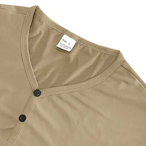 Gros plan du col de t-shirt Henley kaki montrant les boutons et l'étiquette