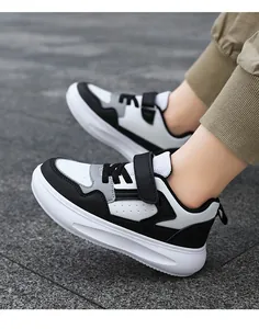 Gros plan de baskets en cuir noir et blanc pour garçons avec des semelles épaisses
