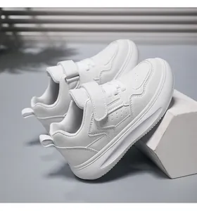 Détail latéral de baskets blanches pour enfants à semelle épaisse avec velcro et lacets