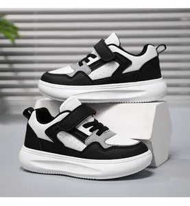 Détail latéral de baskets pour enfants noir et blanc à semelle épaisse avec scratch