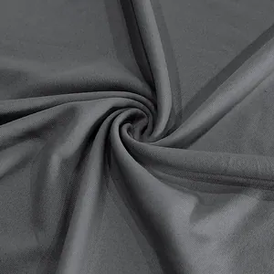 Détail macro d'un tissu gris foncé respirant et élastique à texture côtelée sport.