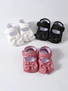Weiche Baby-Prinzessinnenschuhe mit großen Schleifen in den Farben Weiß, Schwarz und Rosa.
