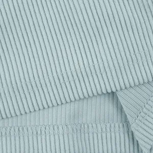 Vue macro montrant la texture côtelée et les coutures du short en velours côtelé bleu.
