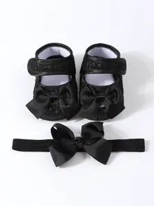 Detailansicht der schwarzen Baby-Prinzessin-Schuhe mit passendem Schleifenstirnband