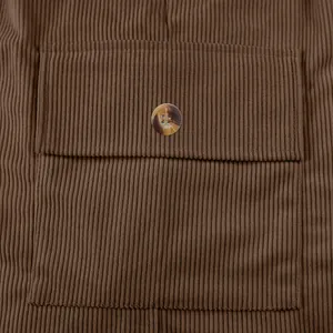 Macro view of the high-quality brown corduroy texture and marbled button on cargo shorts.