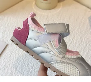 Close-up detail of silver and pink girls' ballet-style sneakers with velcro straps