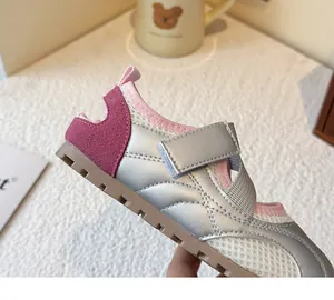 Detailed view of silver metallic girls' ballet style sneakers with pink suede accents