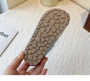 Detail view of the textured rubber sole of a girl's trainer, size 28.