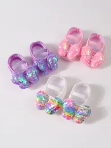 Vista detallada de zapatos de princesa para bebé con lazos de lentejuelas grandes.
