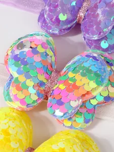 Detalle macro de un lazo de mariposa con lentejuelas de colores en zapatos princesa para bebé