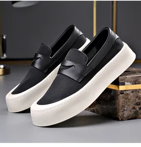 Detailopname van ademende zwarte herenloafers met dikke witte platform-plateauzolen.