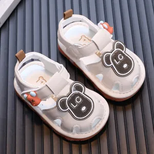 Detailweergave van witte piepende babysandalen met schattige beren en zachte zolen