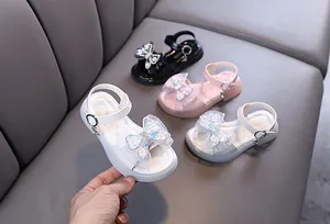 Detailed view of stylish girls' princess sandals featuring rhinestone butterfly bows.