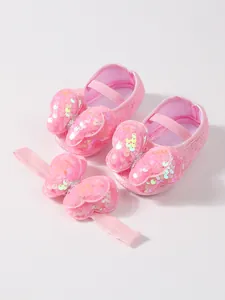 Zapatos de princesa para bebé de encaje rosa con diadema a juego y lazos de lentejuelas.