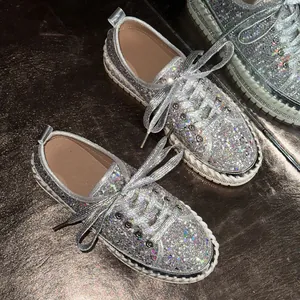 Detailansicht der funkelnden silbernen Pailletten-Sneaker mit Plateausohle und Schnürung