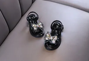Detailed view of black girls' summer princess sandals featuring sparkling butterfly floral bow decorations