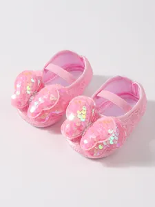 Primer plano detallado de zapatos de princesa para bebé en encaje rosa con lazo lentejuelas