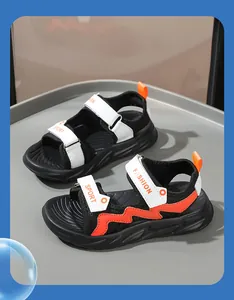 Vista laterale dei sandali da spiaggia traspiranti per bambini in nero, bianco e arancio
