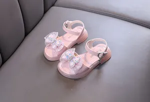Close-up of elegant pink girls' princess sandals featuring sparkly butterfly bow detail