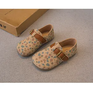 High-quality detail of floral print girls' flats featuring a brown leather buckle strap
