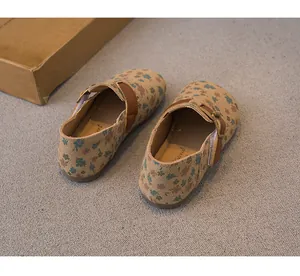 Detailed view of girls' floral print Birkenstock shoes with adjustable metal buckle.