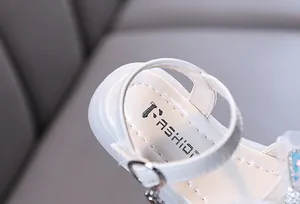 Close-up view of a white girl princess sandal heel featuring an adjustable buckle strap