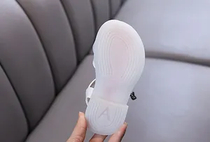 Detailed view of the anti-slip semi-transparent rubber sole on white girls' princess sandals
