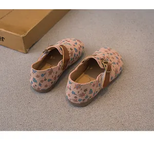 Close-up of pink floral pattern on girls' Birkenstock style clogs with brown leather strap