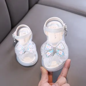 Elegant white girls' princess sandals featuring a large sparkly sequin butterfly bow