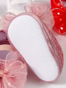 Nahaufnahme der rutschfesten Sohle rosa Babyprinzessinnenschuhe mit Sternenrüschen