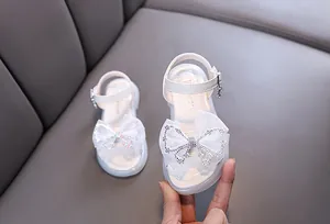Detailansicht weißer Mädchen Prinzessin Sandalen mit funkelnder Strass Schleife.