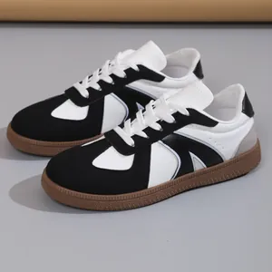 Macro view of retro black and white GAT sneakers with textured leather and gum soles