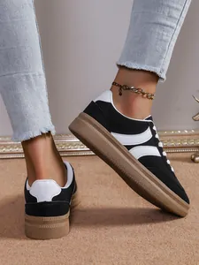 Κομψά ασπρόμαυρα sneakers με χοντρή σόλα σε γερμανικό στυλ που φοράει το μοντέλο