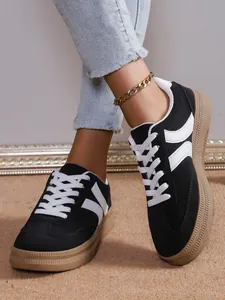 Λεπτομέρεια από κομψά μαύρα sneakers με πλατφόρμα, λευκές ρίγες και σόλα καουτσούκ.