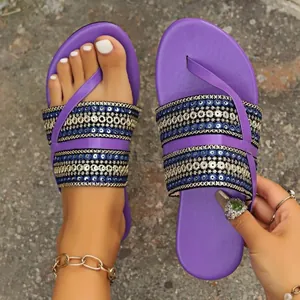 Detailweergave handgemaakte paarse boho etnische platte sandalen met borduursel