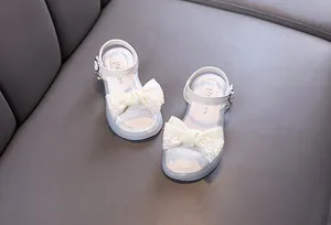 Detailed view of white girls princess sandals featuring delicate lace bow decoration