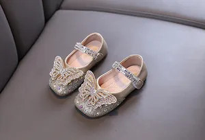 Close-up of champagne gold girls' princess shoes with rhinestone butterfly decoration