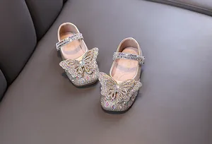 Close-up of sparkling rhinestone butterfly design on gold girl's princess shoes