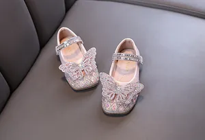 Macro view of pink girl's princess shoes with a shimmering rhinestone butterfly detail