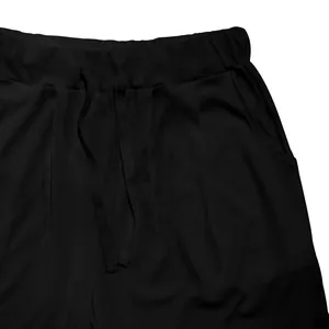 Primer plano de la cintura de pantalones cortos negros de canalé con cordón y bolsillo.