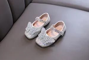 Detailed shot of white toddler princess shoes with rhinestone butterfly decoration
