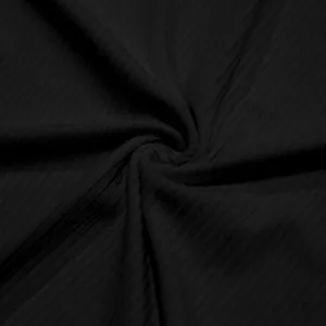 Primer plano de la textura de tela negra acanalada transpirabile para conjunto hombre.