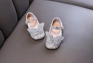 Top view of elegant white girl's princess shoes featuring sparkling crystal butterfly